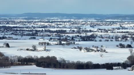 Toma-De-Paisaje-Aéreo-De-Un-Campo-Rural-Cubierto-De-Nieve.