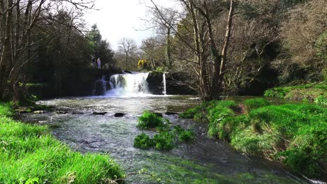 Couple-standing-beside-poulassy-Waterfalls-Kilkenny-Ireland-on-a-warm-spring-day