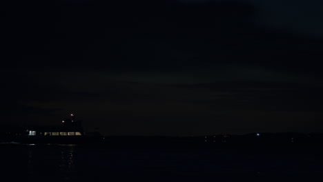 Boat-passing-on-water-at-night