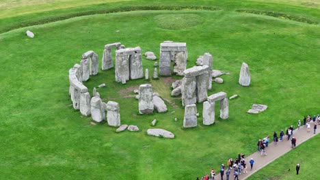 Stonehenge-UNESCO-World-Heritage-Site,-Aerial-View-of-Tourists-Around-Historic-Landmark-60fps
