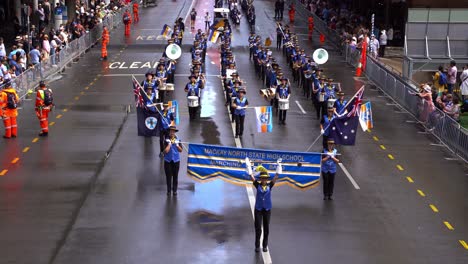 Estudiantes-De-La-Banda-De-Música-De-La-Escuela-Secundaria-Estatal-Del-Norte-De-Mackay-Tocando-Instrumentos-Musicales,-Marchando-Por-La-Calle-Y-Participando-En-La-Tradición-Del-Desfile-Del-Día-De-Anzac