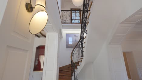 Scenic-hallway-interior-view,-tilt-movement-up-the-stairs-inside-luxurious-renovated-country-house