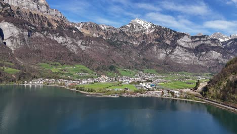 Small-Swiss-village-named-Walenstadt-in-front-of-Alps-with-Lake-Walen-in-foreground