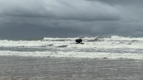 Waves-gently-crash-against-the-coast,-captured-in-slow-motion-on-a-cloudy-day-along-Spain's-coastline,-embodying-the-spirit-of-travel-and-exploration