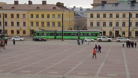 New-street-tram-drives-past-old-cobble-stone-Senate-Square-in-Helsinki