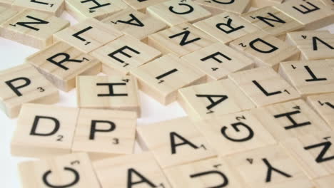 On-white-table-top,-close-up-as-Scrabble-letter-tiles-pushed-into-view