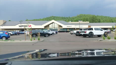 White-Ford-pickup-truck-starts-and-leaves-parking-lot,-POV-from-inside-car