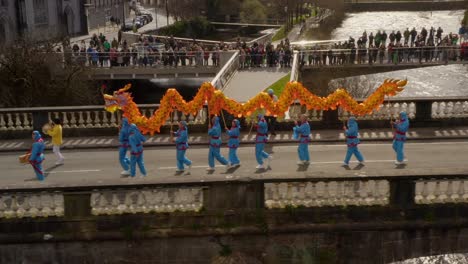 Luftbildverfolgung-Folgt-Paradetrommler,-Der-Drachentanz-Anführt,-Bis-Zum-Rand-Der-Parade,-Die-Sich-über-Dem-Fluss-Corrib-Versammelt