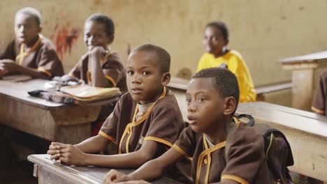 Los-Niños-Visten-Uniformes-Escolares-Y-Se-Sientan-En-Un-Escritorio-En-El-Aula-En-Madagascar,-África.