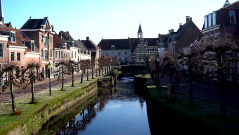 Centro-Histórico-De-La-Ciudad-Medieval-Con-Gente-Caminando-Y-En-Bicicleta-A-Lo-Largo-Del-Histórico-Puerto-Terrestre-Y-Acuático-Koppelpoort-En-Amersfoort