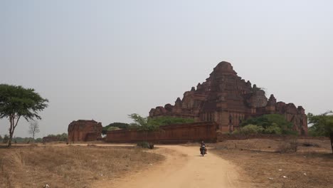Ein-Motorroller-Fährt-Vor-Einem-Tempel-In-Begann,-Myanmar-Vorbei