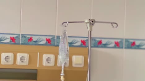 An-infusion-bottle-hanging-on-a-pole-in-a-hospital-ward