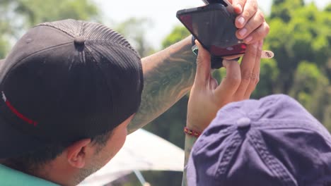 Couple-of-friends-taking-a-photo-of-the-solar-eclipse-from-their-smartphone,-Mexico-April-8,-2024