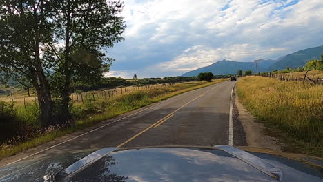 Starting-road-trip-by-driving-into-the-country-on-a-paved-road-near-40-mile-per-hour-sign,-driving-POV-shot