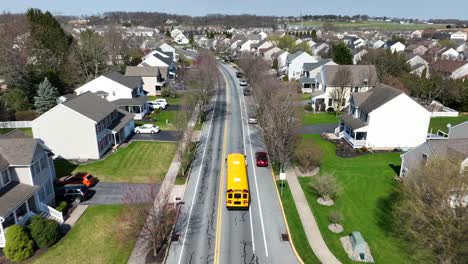Yellow-School-Bus-on-road-in-noble-American-neighborhood-in-spring-season