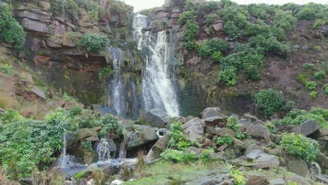 Aerial-drone-footage-of-a-tall-rocky-waterfall-in-the-Yorkshire-Dales,-Pennies