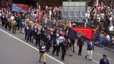 Representantes-De-La-Asociación-Del-Regimiento-Real-Australiano-Caminando-Por-Las-Calles-De-La-Ciudad-De-Brisbane,-Participando-En-El-Desfile-Anual-Del-Día-De-Anzac-Con-Multitudes-Aclamando-A-Lo-Largo-De-La-Calle