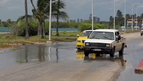 Überschwemmungen-In-Varadero,-Kuba,-Tiefe-Wasserpfützen-Und-Autos-Fahren-Langsam-Und-Vorsichtig