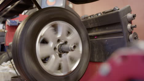 Wheel-spinning-on-wheel-balancer-machine,-side-view-at-tyre-garage