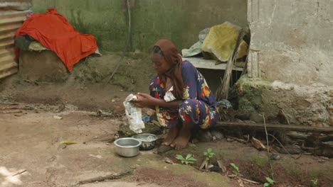 Una-Joven-Tanzania-Con-Pañuelo-En-La-Cabeza-Lavando-Un-Trapo-En-Pequeños-Tazones-De-Hojalata-En-La-Calle