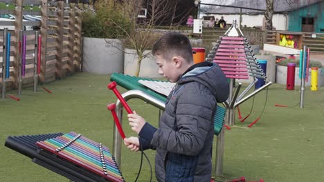 Editorial-video-footage-of-a-young-boy-playing-on-musical-attractions-in-a-public-area