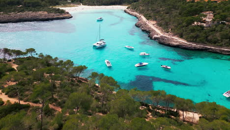 Scenic-aerial-view-of-Cala-Mondrago-beach-in-Mallorca-with-boats
