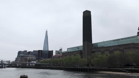 Crossing-over-the-water-close-to-Tate-Modern-and-The-Shard-along-the-River-Thames-in-London,-evoking-the-essence-of-travel-and-exploration