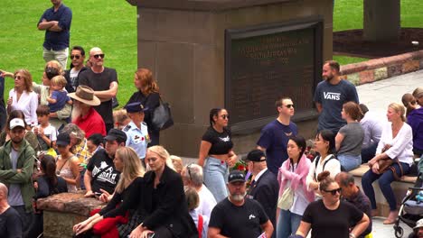 Large-crowds-of-people-gather-in-downtown-Brisbane-city,-swelling-with-anticipation-before-the-commencement-of-the-annual-tradition-Anzac-Day-parade-at-Anzac-Square,-close-up-shot