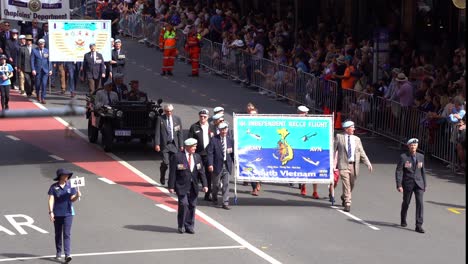 Former-and-current-service-people-walking-down-the-street-of-Brisbane-city,-participating-in-annual-Anzac-Day-parade,-solemn-day-of-public-remembrance