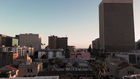 Hermosa-Inclinación-Aérea-Cinematográfica-De-Un-Denso-Paisaje-Urbano-En-Las-Primeras-Etapas-Del-Atardecer.