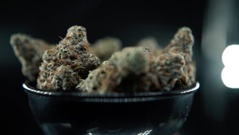 A-macro-detailed-pan-right-shot-of-a-cannabis-plant,-hybrid-orange-strains,-sativa-,marijuana-flower,-on-a-rotating-stand,-Full-HD,-super-slow-motion,-120-fps,-studio-lighting