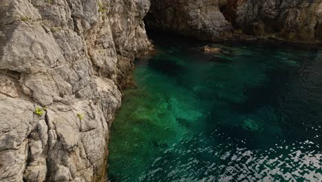 Insel-Kalamota,-Adria,-Kroatien-–-Das-Durchscheinende-Azurblaue-Wasser-Unter-Den-Steilen-Und-Schroffen-Klippen-–-Luftaufnahme-Einer-Drohne