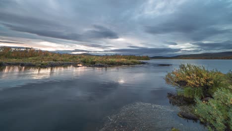 Fast-moving-stormy-clouds-cover-the-sky-as-the-sun-sets,-and-darkness-descends-over-the-landscape