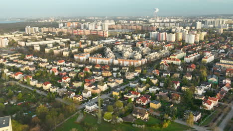 Aerial---panoramic-aerial-view-of-a-mixed-urban-landscape-during-daylight,-contrasting-dense-apartment-blocks-with-a-suburban-area-sprinkled-with-detached-houses-and-verdant-patches---Gdańsk-Oliwa