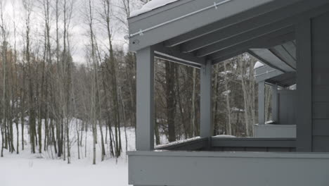 Slow-motion-shot-of-water-dripping-and-snow-melting-off-of-a-roof