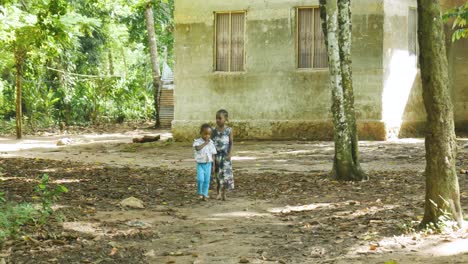 Two-young-small-Tanzania-village-children-walking-outdoors-in-rural-African-neighbourhood