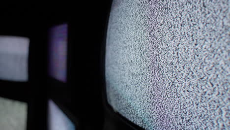 A-close-up-angle-of-cathode-tv-screens-showing-only-a-steady-white-noise-signal-in-a-dark-and-isolated-room