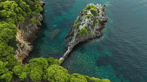 Isla-De-Kalamota,-Mar-Adriático,-Croacia:-La-Escarpada-Costa-Debajo-De-Los-Acantilados-Con-Vegetación-Contrasta-Con-Las-Claras-Aguas-Azules:-Disparo-De-Drones-En-órbita