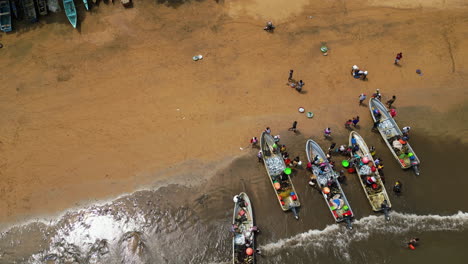 Los-Lugareños-Ayudan-A-Los-Pescadores-A-Obtener-Sus-Capturas-De-Los-Barcos-En-Una-Playa-Africana---Vista-Aérea