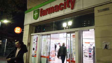 Eingang-Zur-Farmacity-Apotheke-In-Buenos-Aires,-Argentinien,-Medizinisches-Geschäft-Bei-Nacht,-Wahrzeichen-Der-Stadt-Für-Waren-In-Der-Argentinischen-Hauptstadt,-Menschen,-Käufer-Und-Fußgänger,-Die-Vorbeigehen