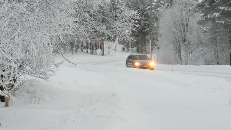 Car-Driving-on-Snow-Covered-Road-in-Wintertime-Lapland-landscape-SLOMO