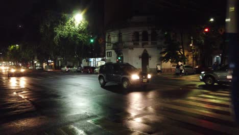 Bueses-Autobus-Drive-En-La-Avenida-Nocturna-En-El-Tráfico-De-La-Ciudad-Latinoamericana-Asfalto-Mojado-Clima-Lluvioso,-Ciudad-De-Buenos-Aires-Barrio-De-Flores-Argentina