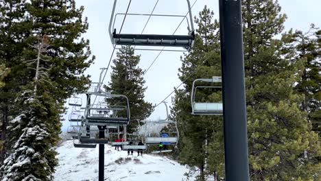 Gente-Montando-Un-Remonte-Aéreo-A-Través-De-Las-Montañas-Alpinas-Cubiertas-De-Nieve-Del-Lago-Tahoe