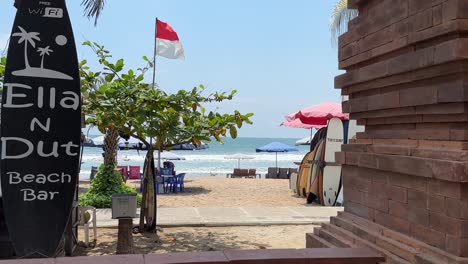 Beach-Bar-Club-in-Legian,-Bali,-Indonesia-with-life-saving-flag-and-surfboards