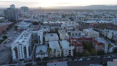 Push-in-drone-shot-of-urban-city-neighborhood-at-sunset