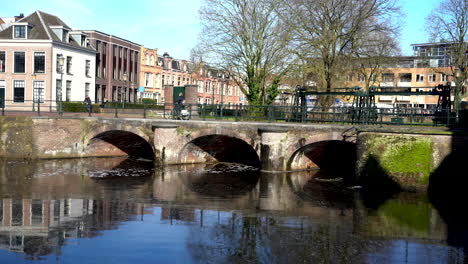 Centro-Histórico-De-La-Ciudad-Medieval-Con-Gente-Caminando-Y-En-Bicicleta-A-Lo-Largo-Del-Histórico-Puerto-Terrestre-Y-Acuático-Koppelpoort-En-Amersfoort