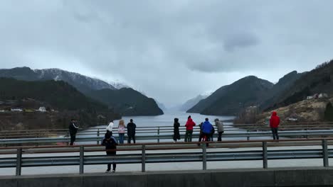 Tourists-admire-fjord-view-towards-remote-Veafjord-from-a-local-bridge