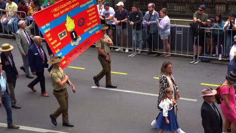 Former-servicemen-and-families-walking-down-the-street,-participating-in-annual-Anzac-Day-parade-in-Brisbane-city,-honour-those-who-serviced-and-sacrificed-during-war-conflicts