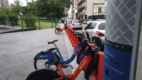Closeup-public-bicycle-service-cycle-bike-parked-lot-at-public-urban-green-park-in-latin-american-city-streets