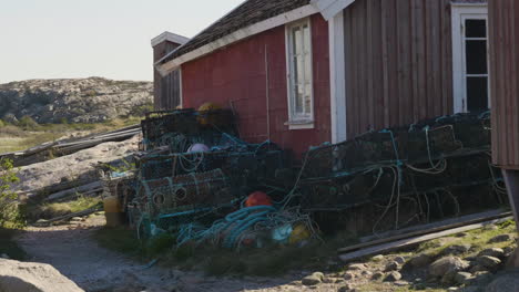 Lobster-Pots-Outside-a-Fisherman´s-Hut,-Swedish-West-Coast,-Pan-shot